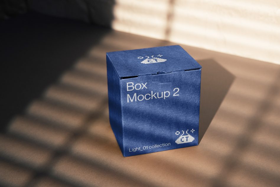 Blue box packaging mockup design on shadowed surface, ideal for presentations and showcasing graphic designs.